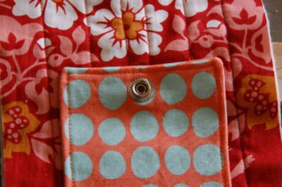 red, blue and coral fabric during construction process with sewing notions