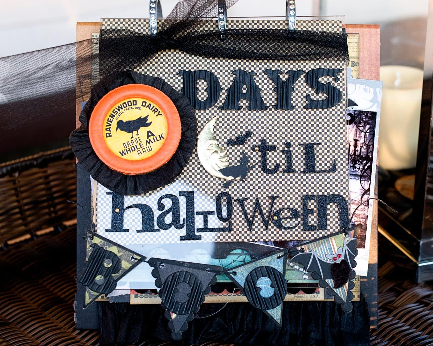 Collage style flip book scrapbook halloween album in black and orange on table