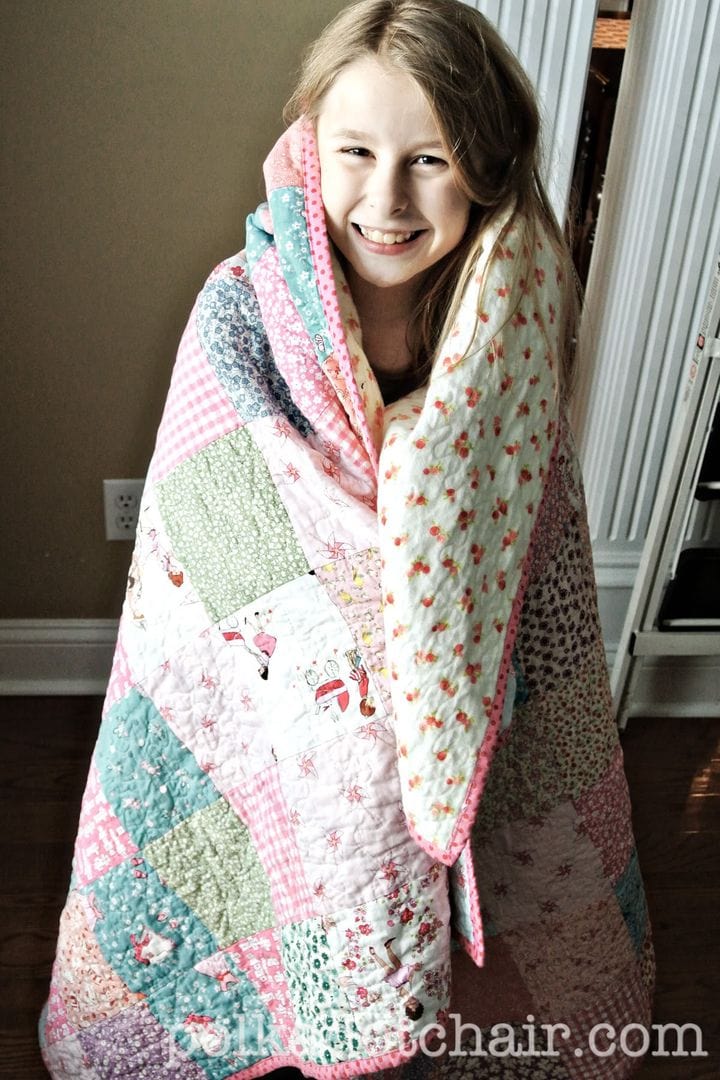girl wrapped up in handmade quilt