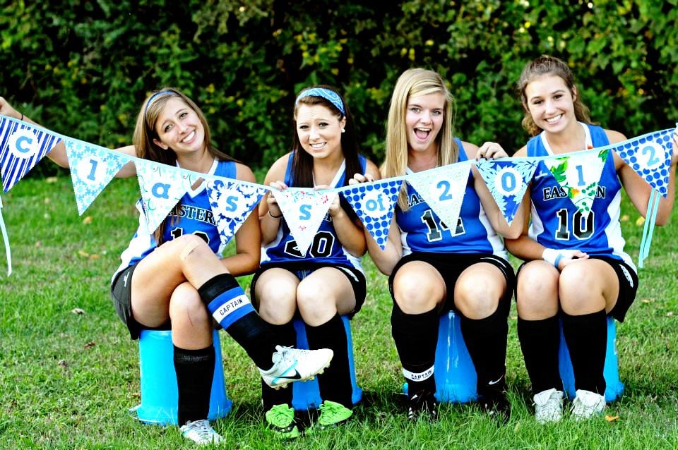 Girls holding colorful pennant outside