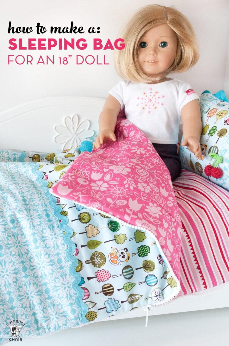 american girl doll sitting on pink and blue sleeping bag