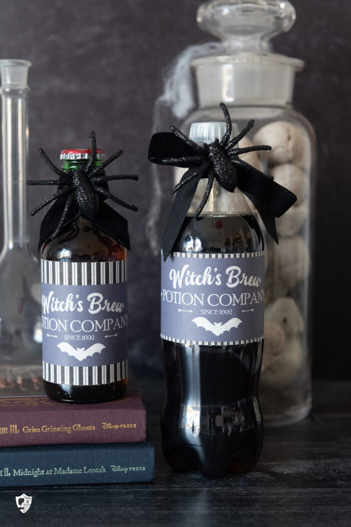 two bottles of diet coke with witches brew labels dark table