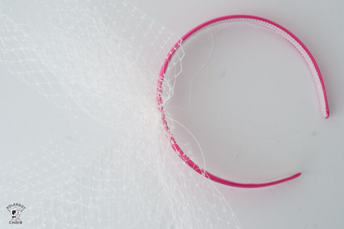 pink headband and tulle netting on white table