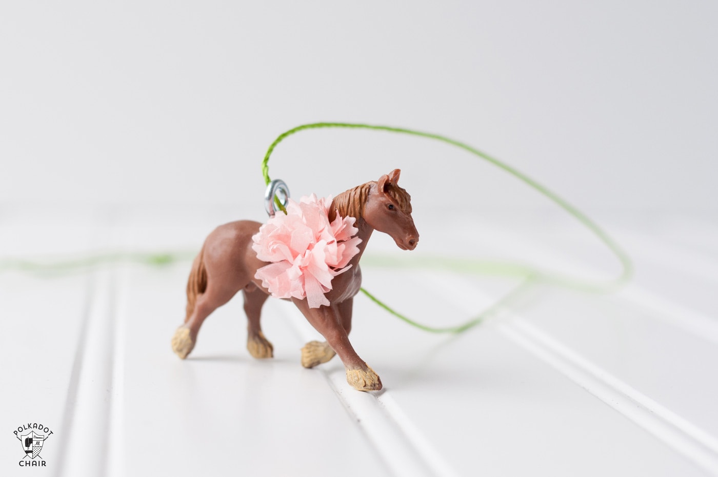 plastic horses on a table with paper flowers