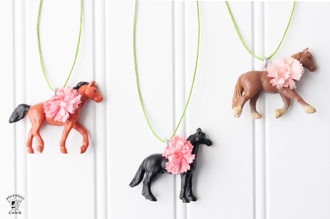plastic derby horses hanging on wall with paper flowers