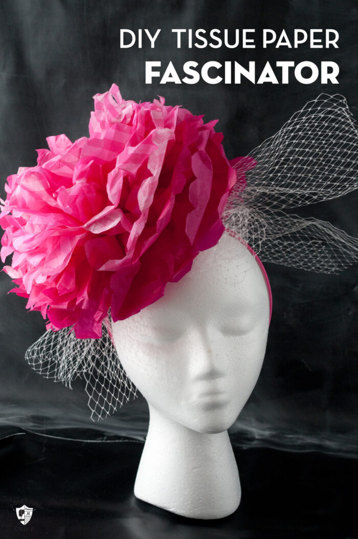 pink paper flower fascinator on white head on black background