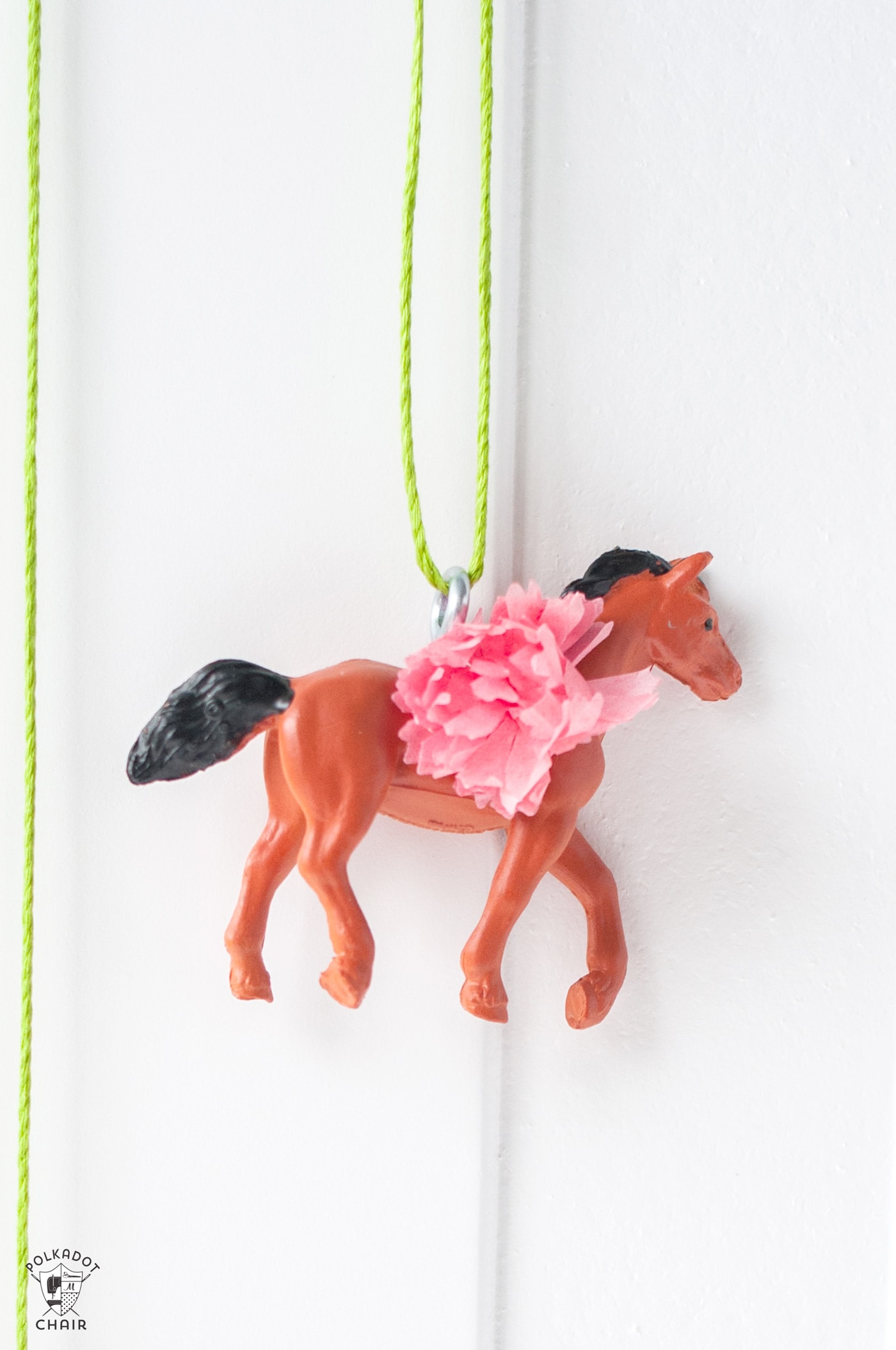 plastic horses on a table with paper flowers