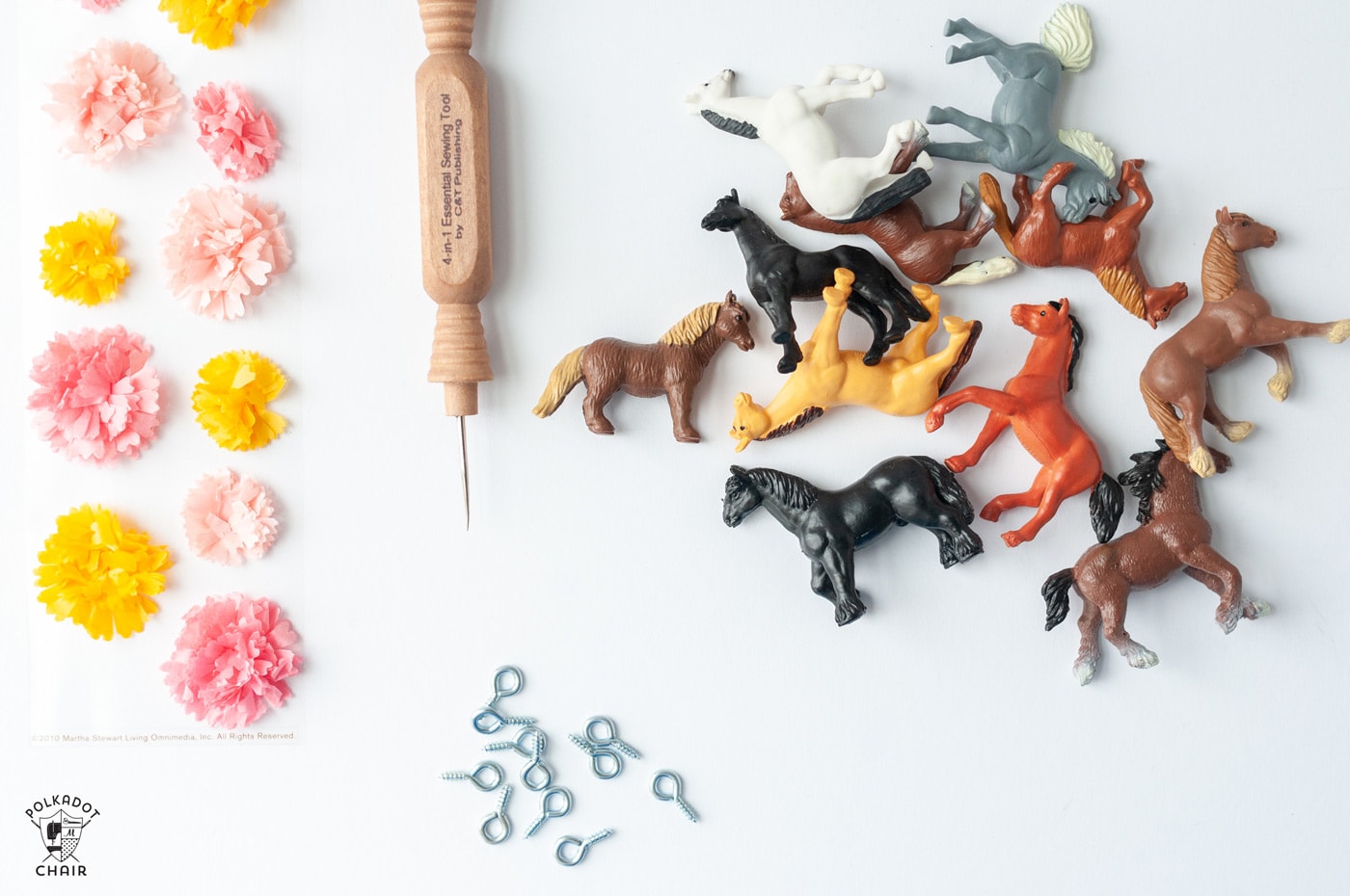 plastic horses on a table with paper flowers