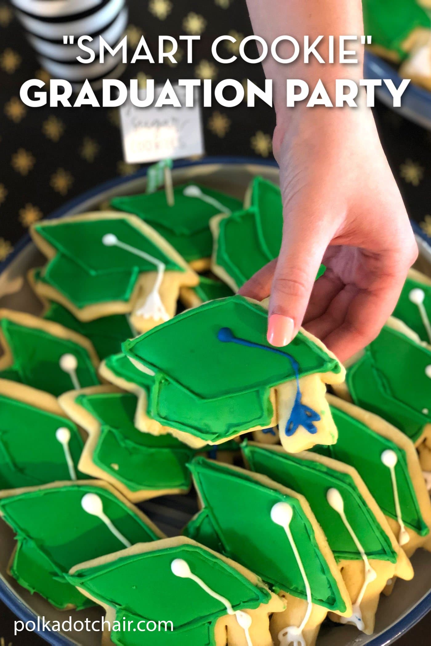 hand holding green graduation cookie