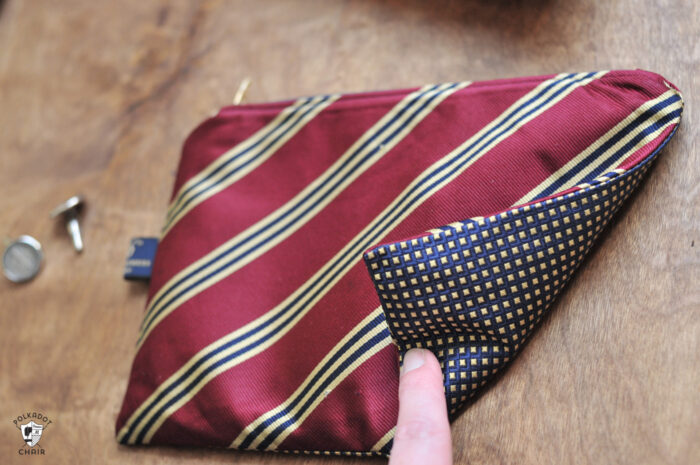 Upcycled neck tie zip pouch on brown table