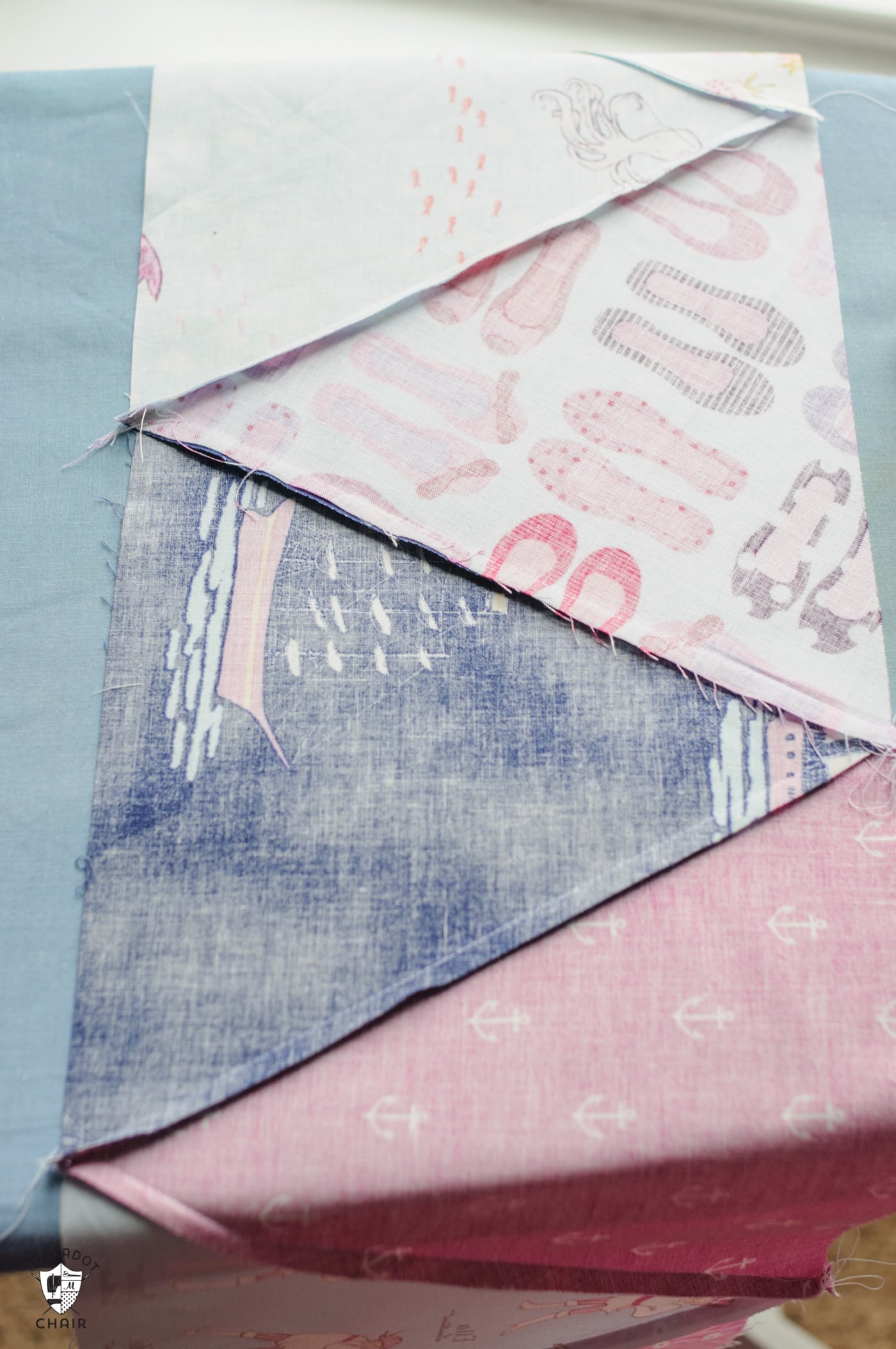 pink and blue fabric on ironing board with iron