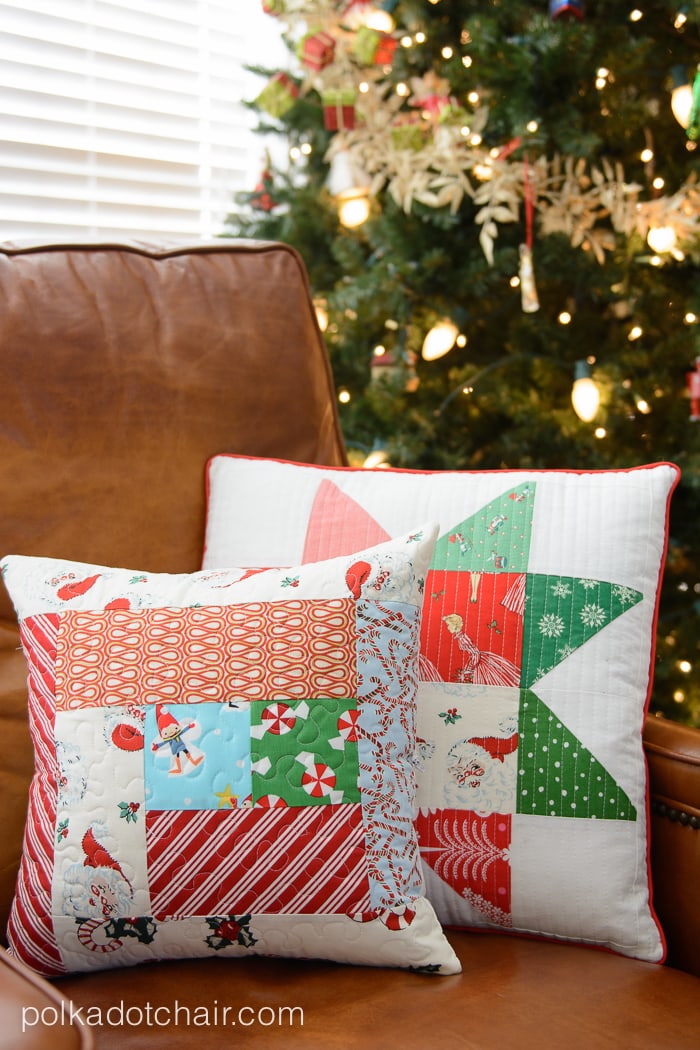 Christmas themed pillows on brown chair next to Christmas tree.