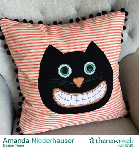 Orange stripe pillow with black cat face on couch