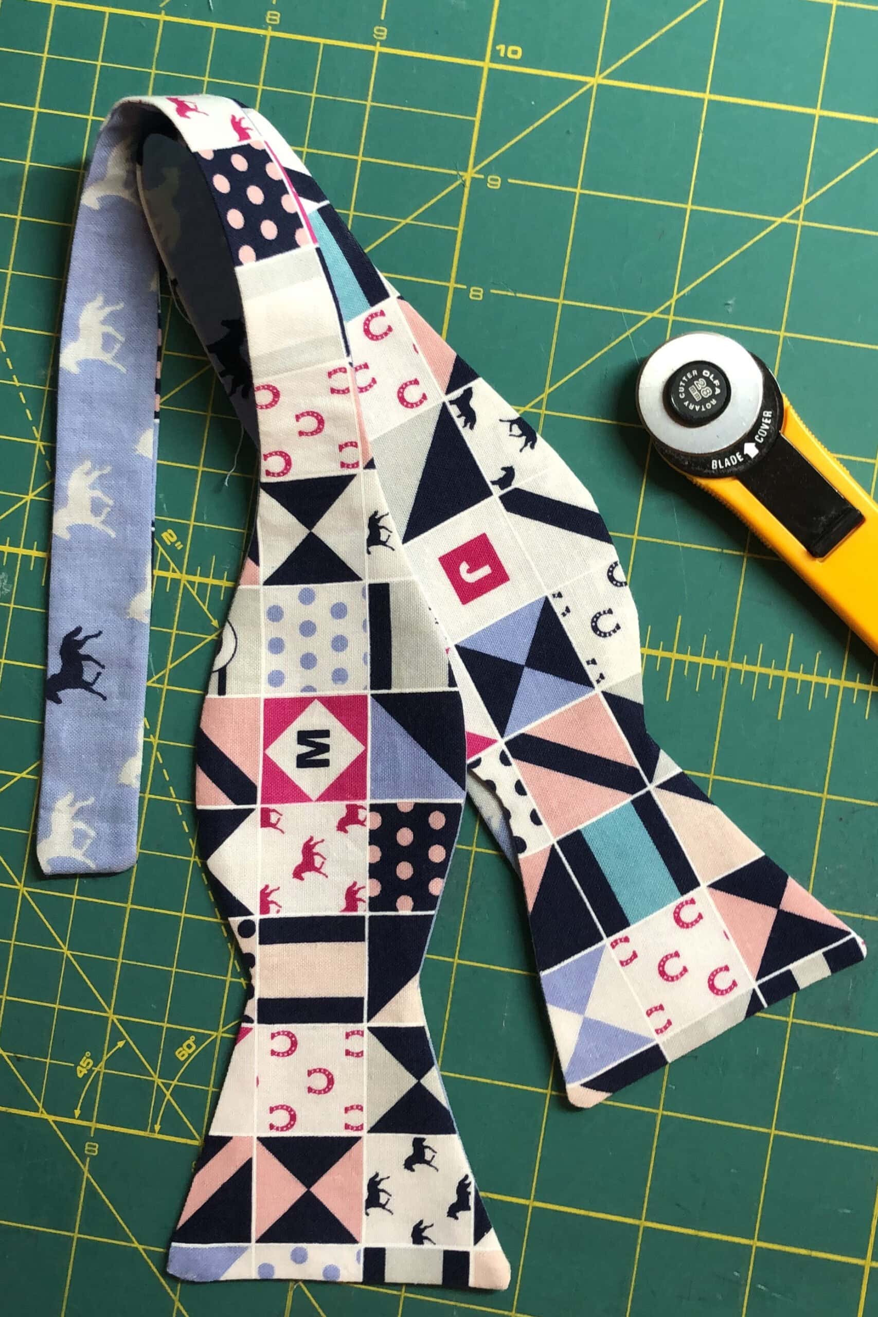 Sewn bow tie on green cutting mat with rotary cutter