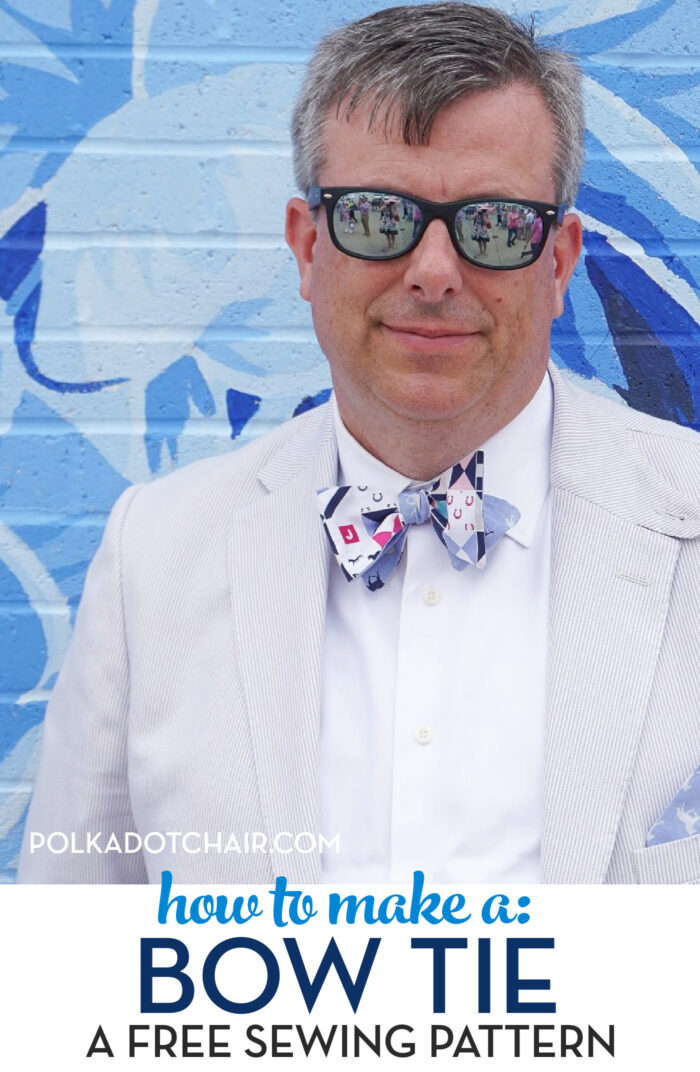 man wearing pink blue bow tie in front of blue wall