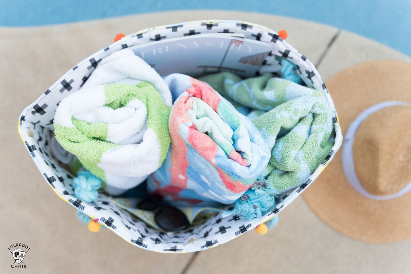 Beach bag full of towels next to pool
