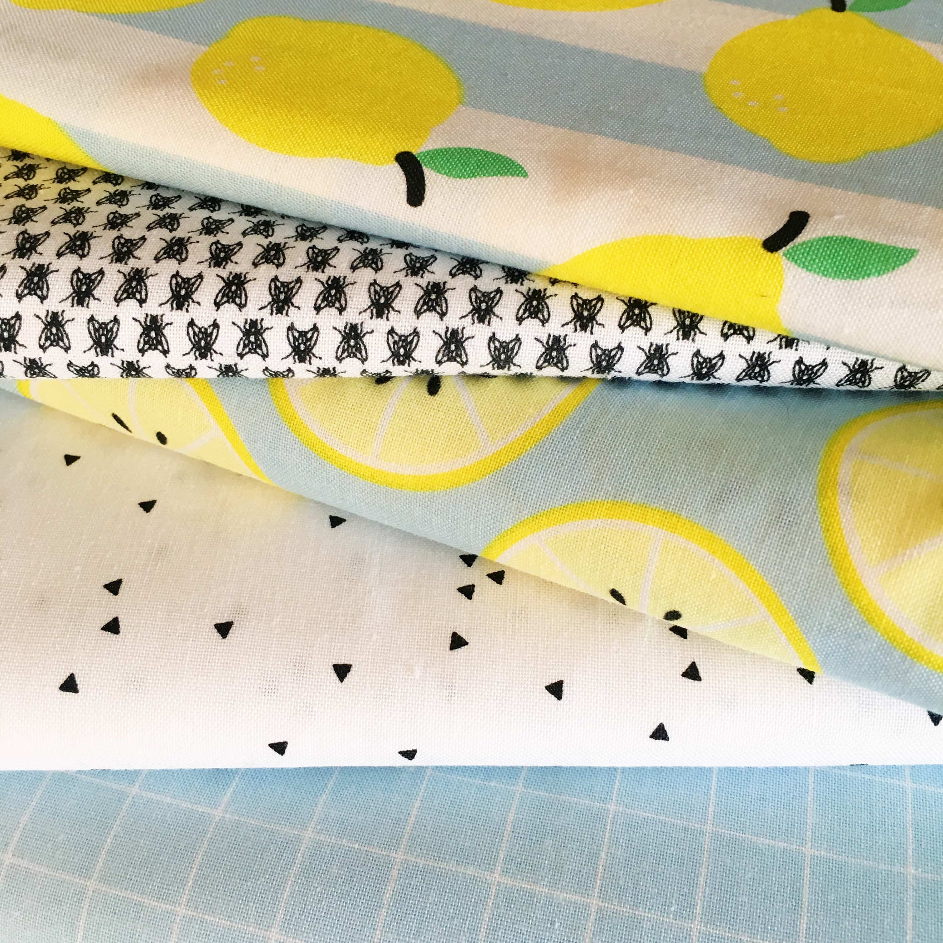 Lemon themed fabrics stacked on top of each other