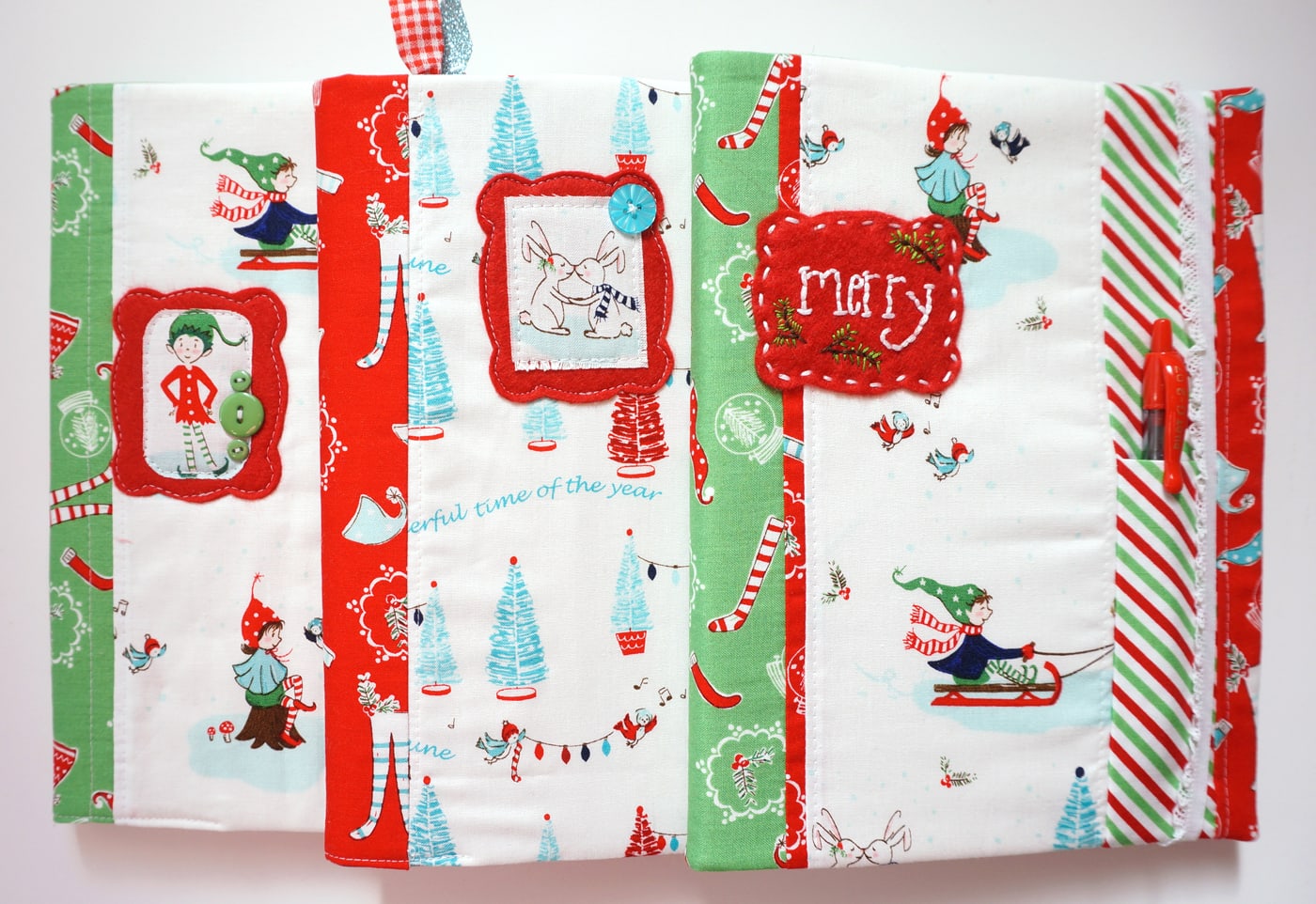 Christmas themed fabric planner cover on white table.