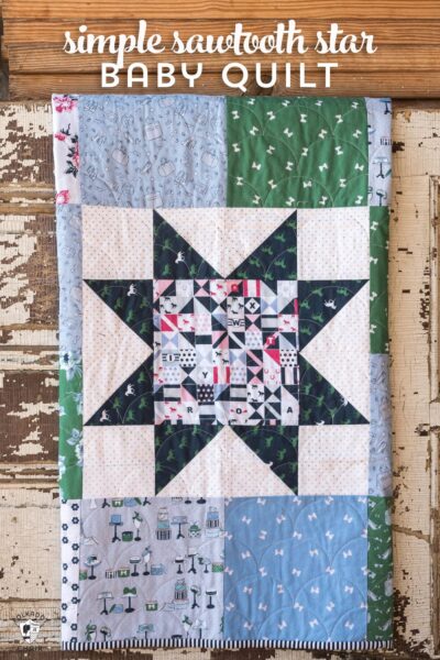 Sawtooth star baby quilt hanging on old door