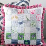 Free sewing pattern for a pom pom patchwork pillow. Uses a fun cheater way to make the points match up- Free pillow pattern