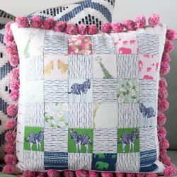 Free sewing pattern for a pom pom patchwork pillow. Uses a fun cheater way to make the points match up- Free pillow pattern