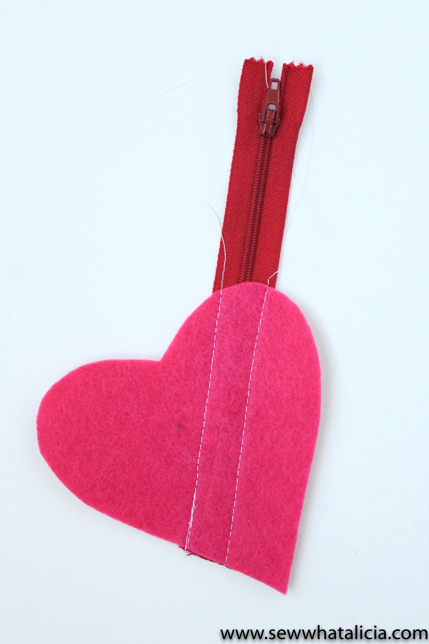 Felt Heart DIY Earbud Pouch - a free tutorial, makes a cute easy to make Valentine's Day gift. #earbudpouch #DIYearbudpouch #valentinesdaycrafts #valentinesdaygifts #diyvalentines #sewingproject #sewingpattern