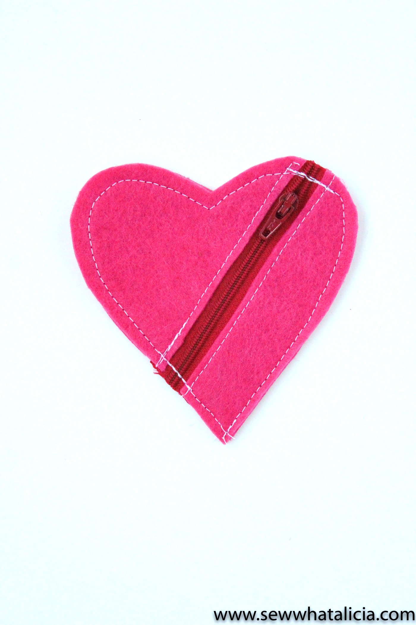 Felt Heart DIY Earbud Pouch - a free tutorial, makes a cute easy to make Valentine's Day gift. #earbudpouch #DIYearbudpouch #valentinesdaycrafts #valentinesdaygifts #diyvalentines #sewingproject #sewingpattern