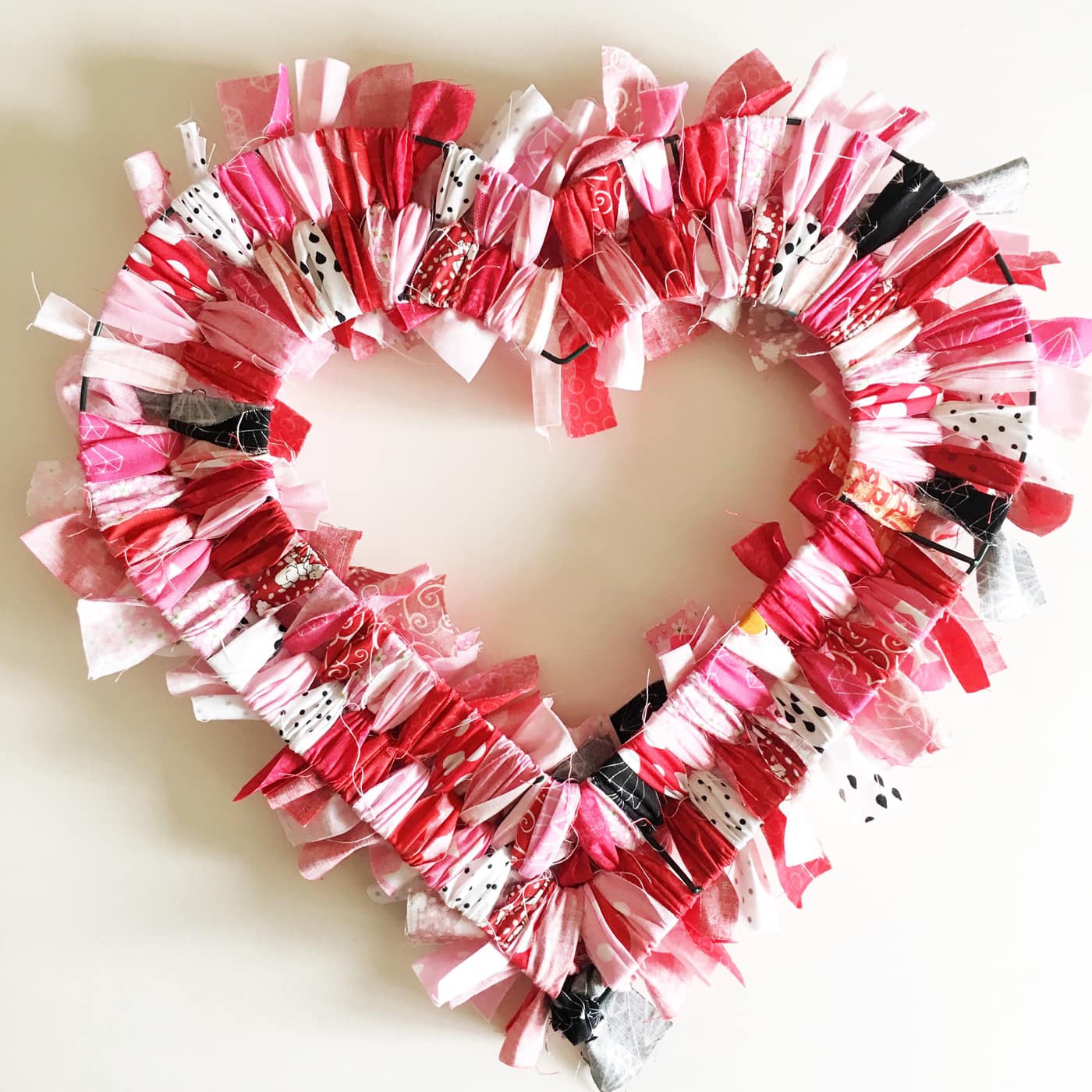 How to make a Valentine's Heart Fabric Rag Wreath- a cute Valentine's Day Craft idea. Rag Wreath Tutorial #ValentinesDayCrafts #DIYWreath #RagWreath #FabricWreathTutorial