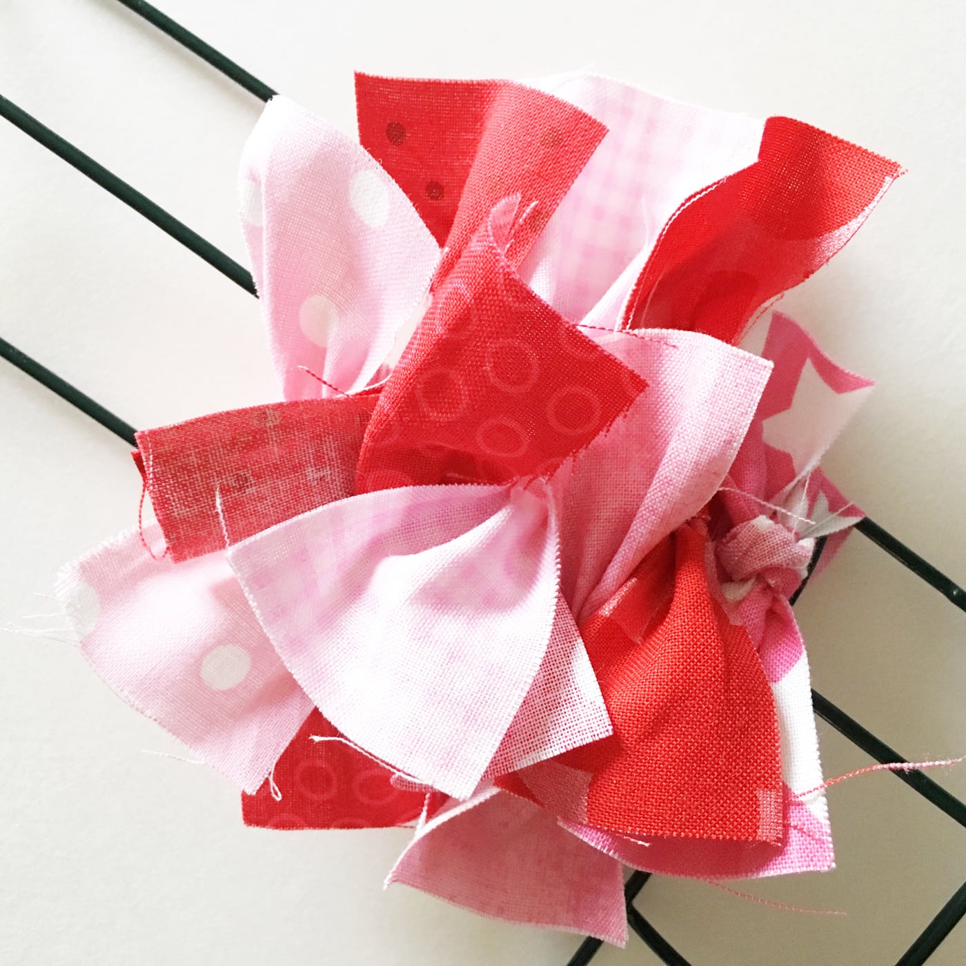 How to make a Valentine's Heart Fabric Rag Wreath- a cute Valentine's Day Craft idea. Rag Wreath Tutorial #ValentinesDayCrafts #DIYWreath #RagWreath #FabricWreathTutorial