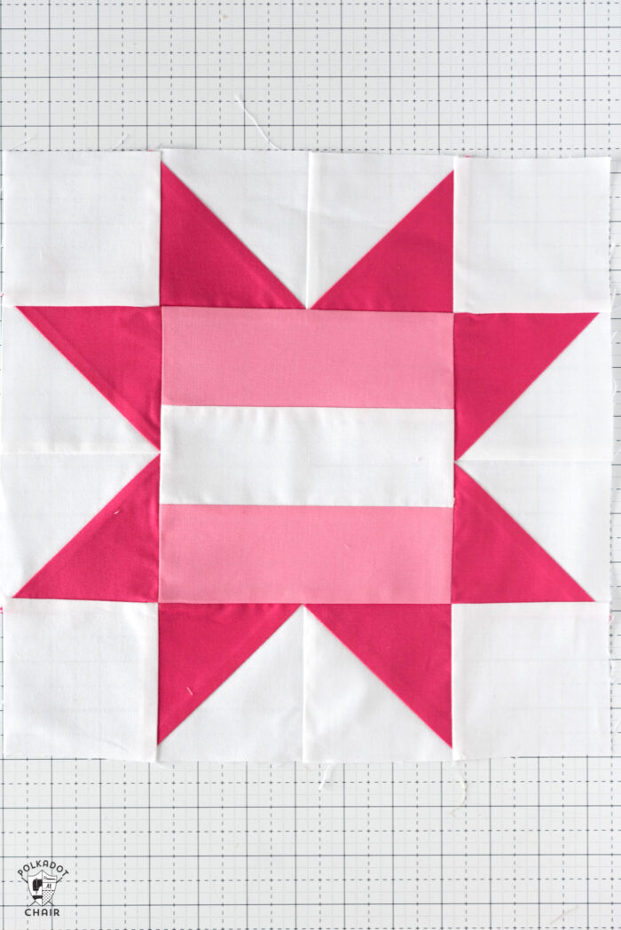 Light pink and dark pink Quilt block on white table.