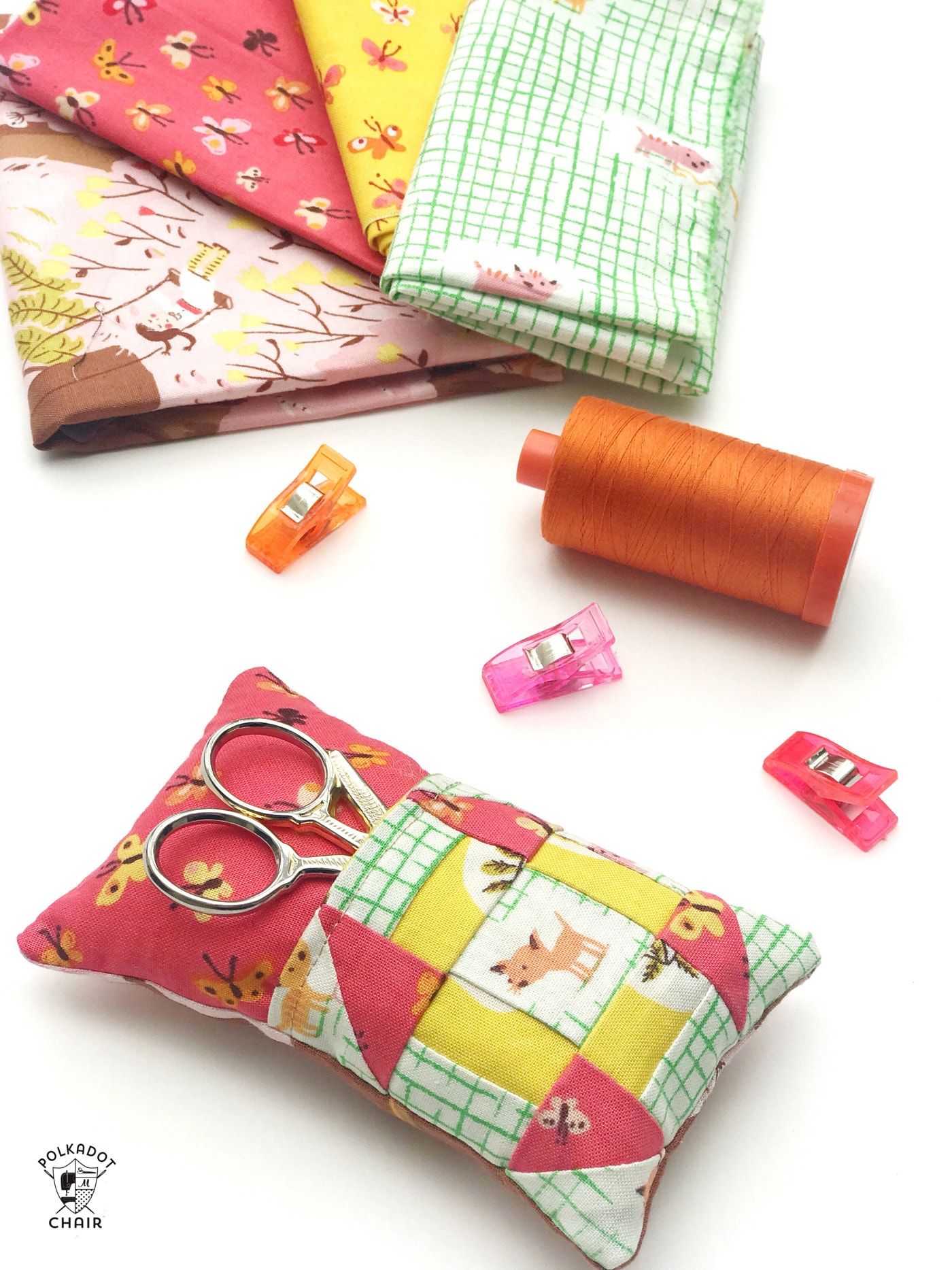 Learn how to make a cute pincushion with a pocket to hold your scissors! A free pincushion sewing tutorial- love the churn dash quilt block addition! #pincushions #DIYpincusions #pincushionstosew #pincushionpatterns #Cutepincushions #sewingtutorial #sewing