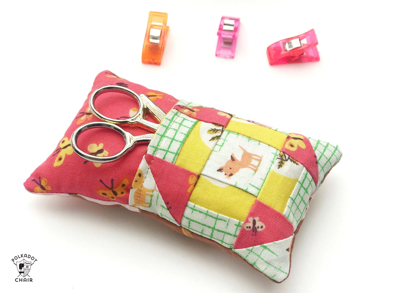 Learn how to make a cute pincushion with a pocket to hold your scissors! A free pincushion sewing tutorial- love the churn dash quilt block addition! #pincushions #DIYpincusions #pincushionstosew #pincushionpatterns #Cutepincushions #sewingtutorial #sewing