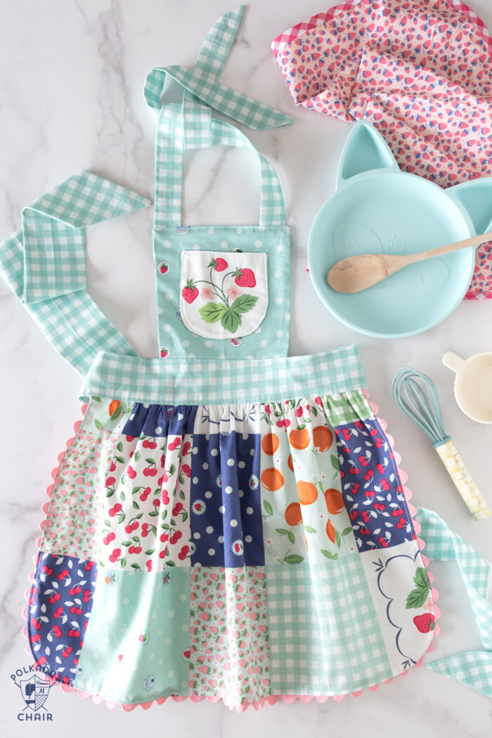 blue apron on white countertop with kitchen utensils