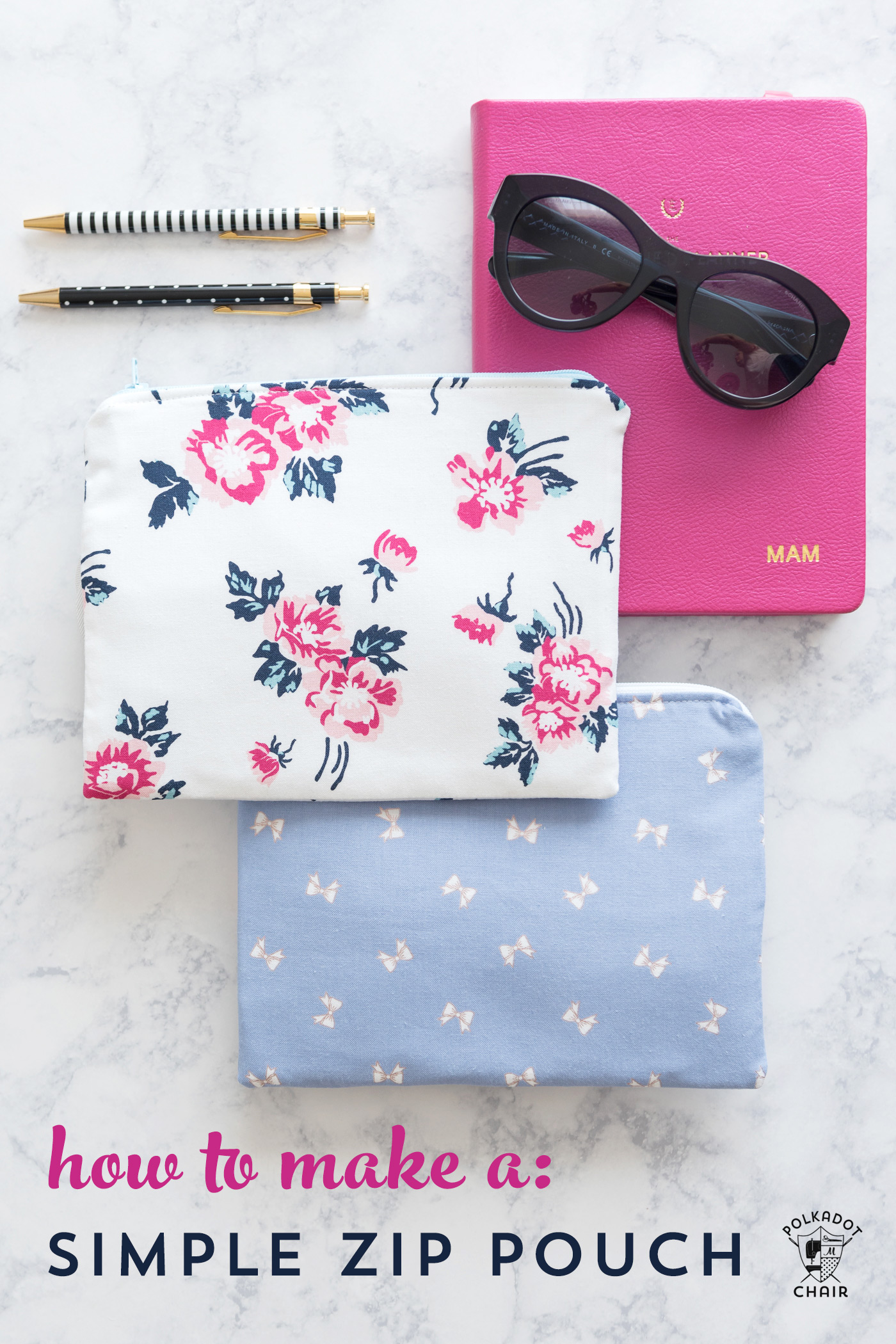 two zip pouches on white marble table with pink book and pens