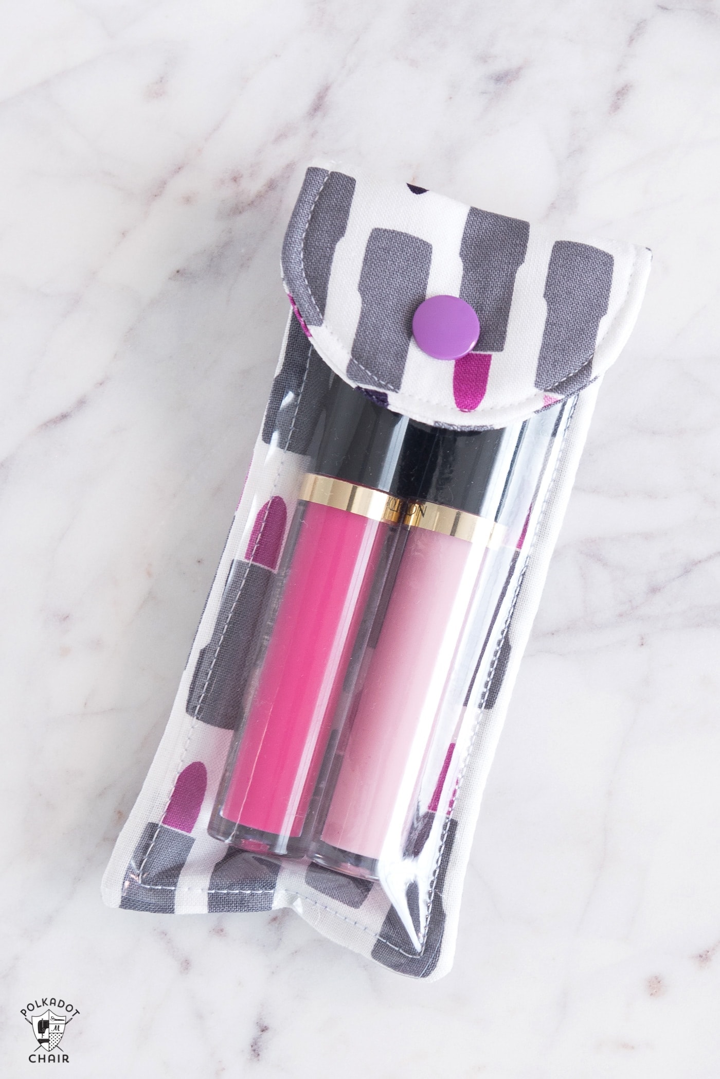 lip gloss pouch on marble tabletop with lipstick in it