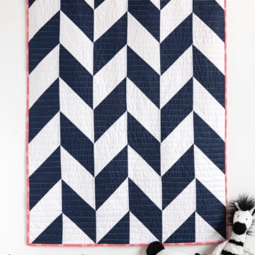 navy and white herringbone quilt on white wall