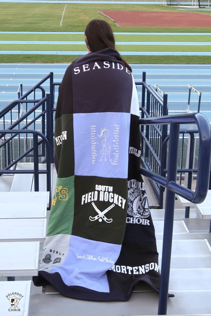 girl wrapped in blanket in athletic stadium