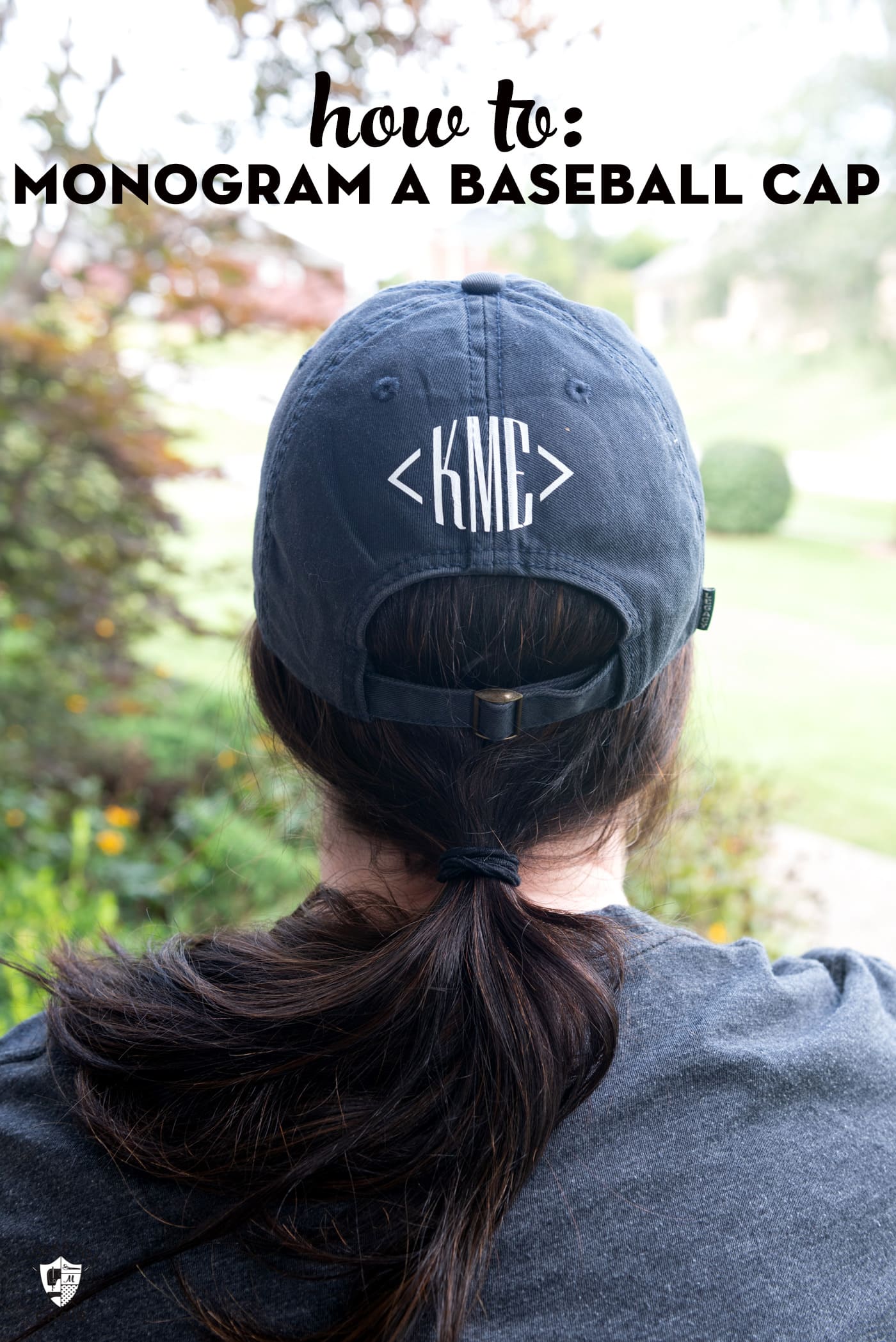 Back of girls head waring a navy baseball cap with white monogram "KME". 