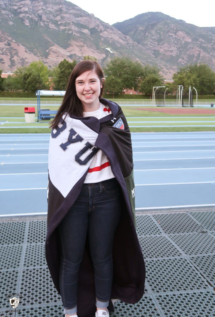 Girl with sweatshirt blanket at track and field