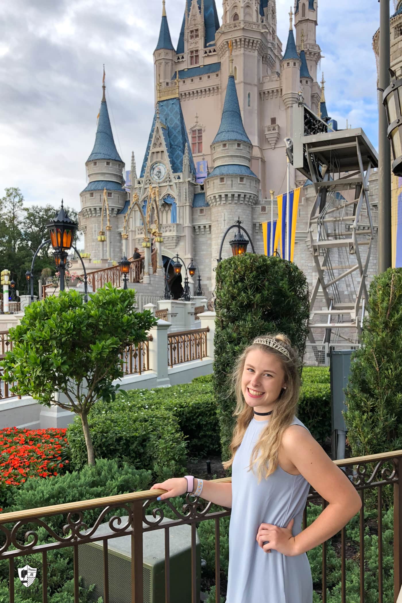 girl in blue dress in front of cinderella castle