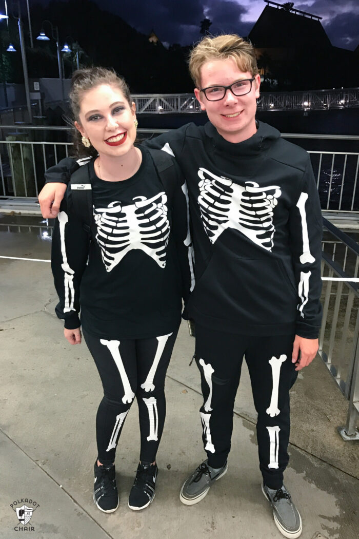 Teens in skeleton halloween costumes on dark night