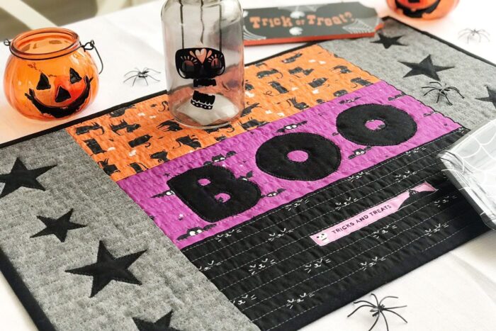 quilted halloween placemat on table with halloween decorations