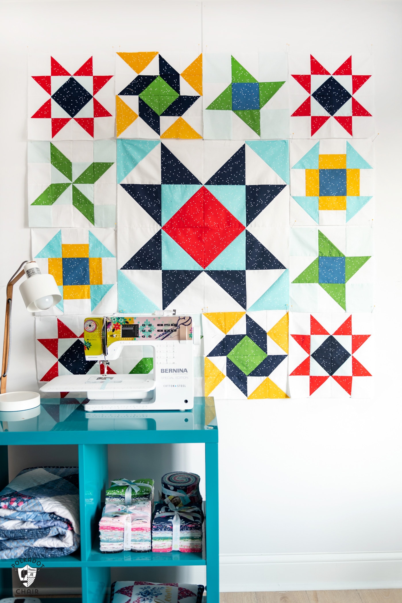 red, blue yellow and green quilt blocks on white wall with sewing machine
