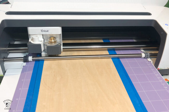 Cricut machine cutting basla wood on purple cutting mat