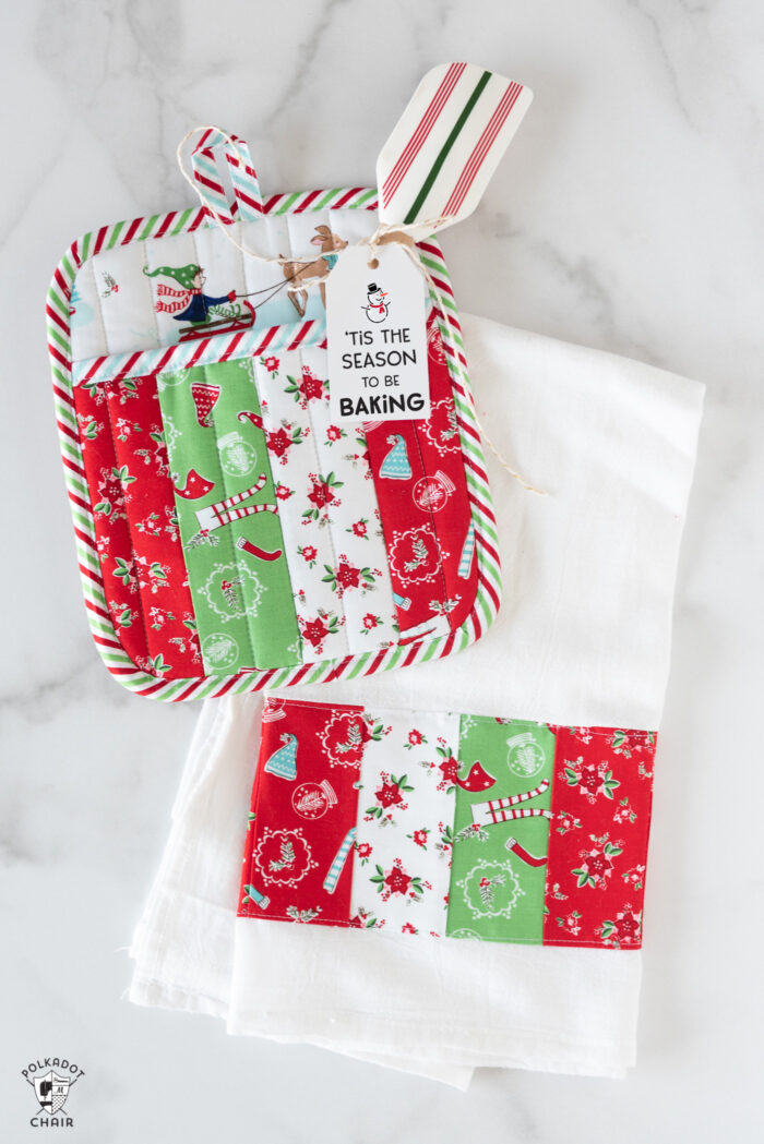 Striped potholder and Christmas dishtowel on white marble table