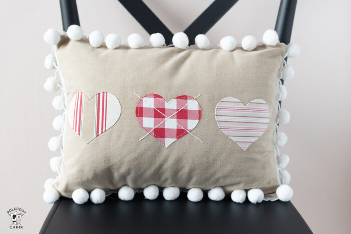 Heart Valentine Pillow on black chair in front of pink wall