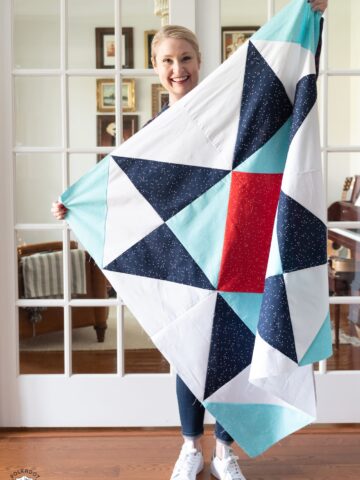 woman holding red white and blue baby quilt