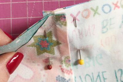 two quilt blocks pinned together along seam