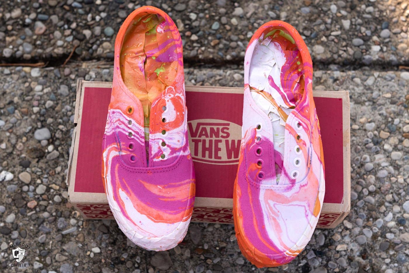 pink orange and white vans drying on a red vans shoe box outside