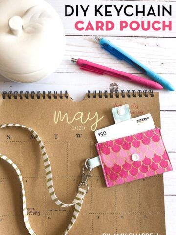 pink keychain card pouch on brown calendar on white tabletop